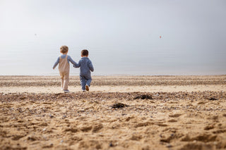 Aneby models holding hands walking towards the sea