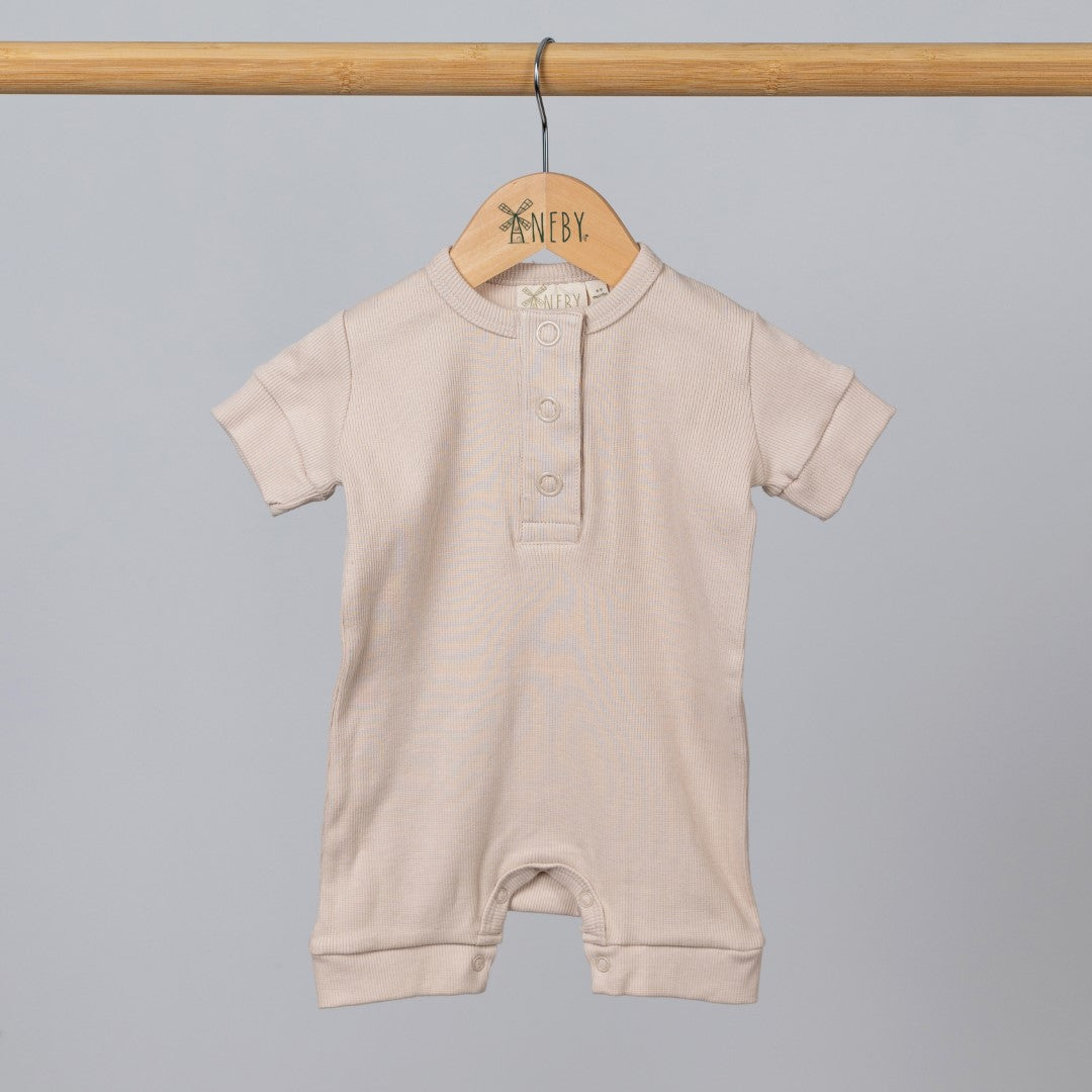 Oat short sleeve rib baby romper hanging, front view.