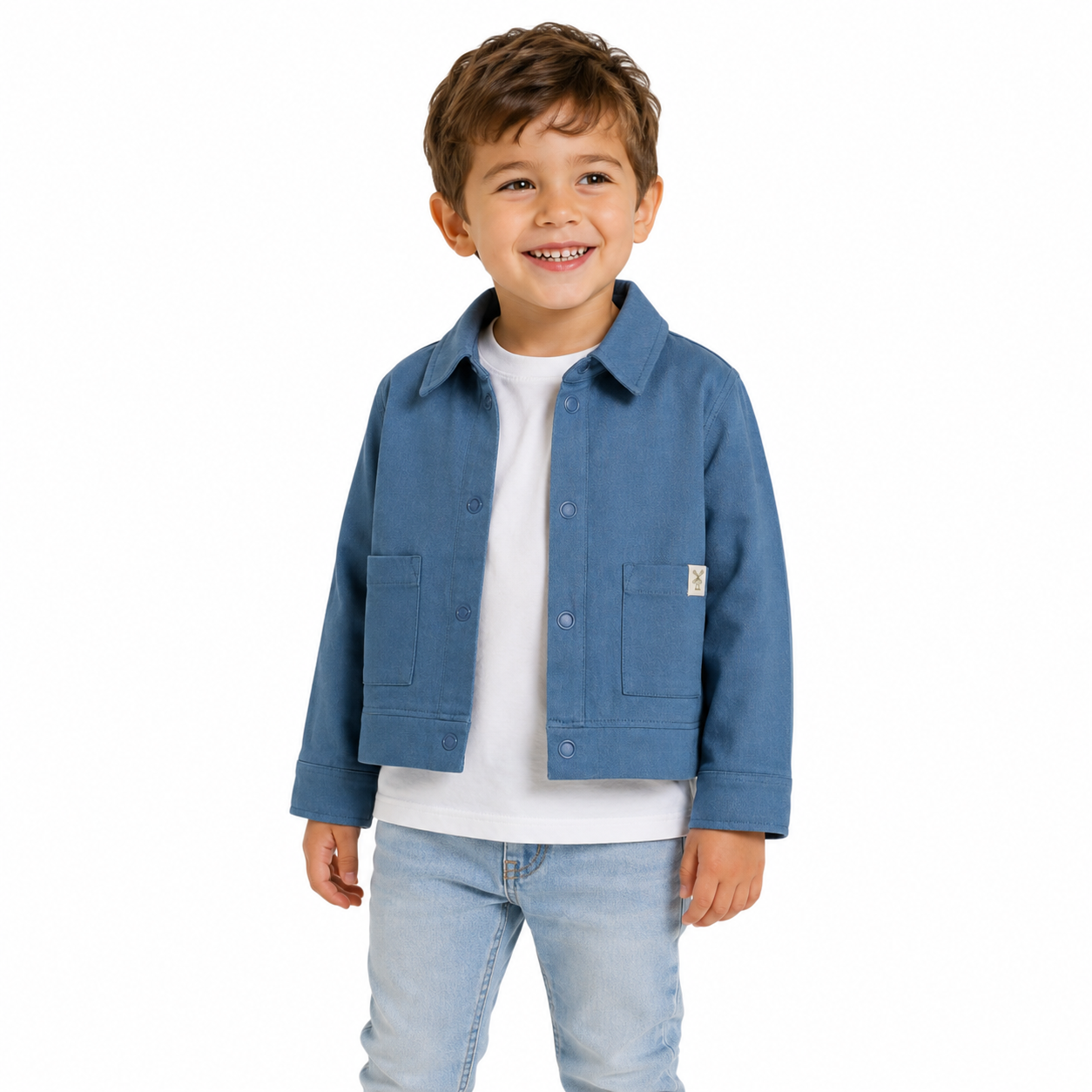 A young boy smiling and wearing a blue jacket over a white t-shirt and light blue jeans, photographed against a plain white background.