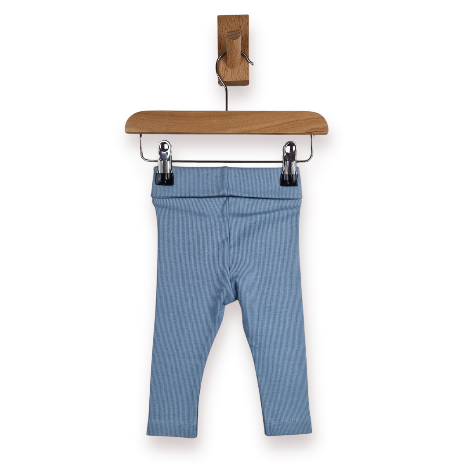 Dusty blue baby leggings hanging from a wooden hanger with metal clips against a plain white background.