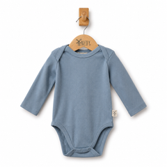 A baby long-sleeve bodysuit in dusty blue ribbed fabric, hanging on a wooden hanger against a clean white background.