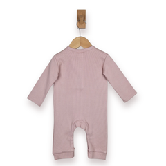 A dusty pink long-sleeve baby jumpsuit or footless romper hanging from a wooden hanger on a white background.