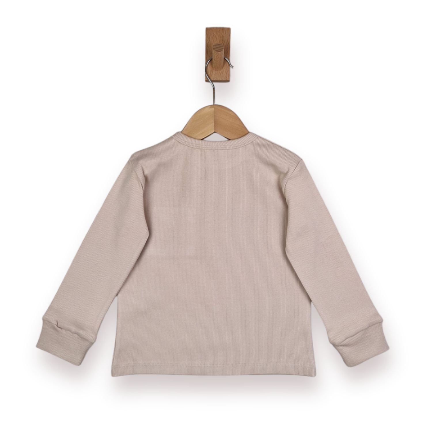 A light beige long-sleeve knit top hanging on a wooden hanger with a wooden peg, shown from the back against a white background.