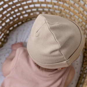 Close up of young baby wearing an Aneby beanie hat