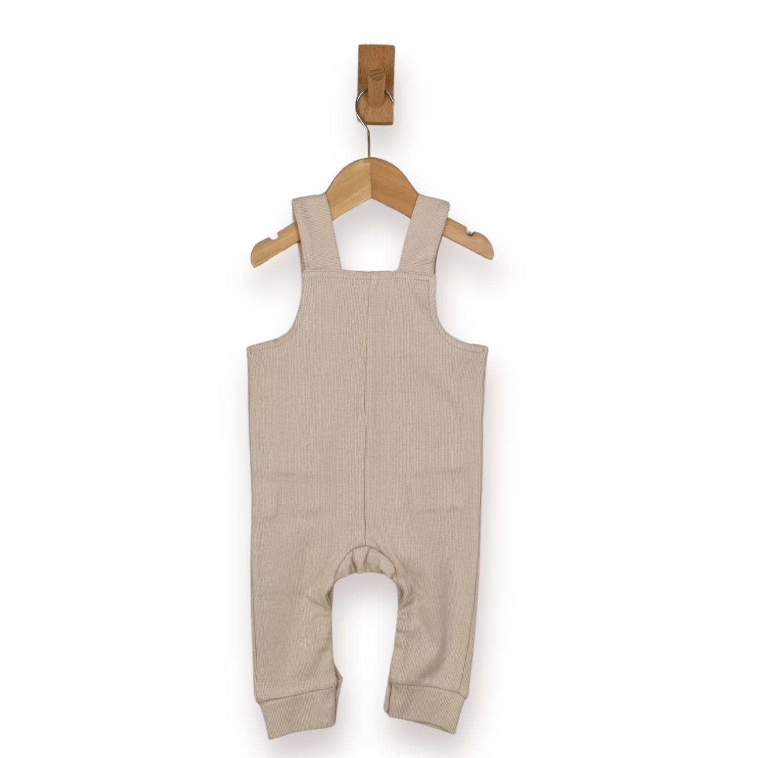 A baby's ribbed knit overall romper in a light beige color, hanging from a wooden hanger on a white background.