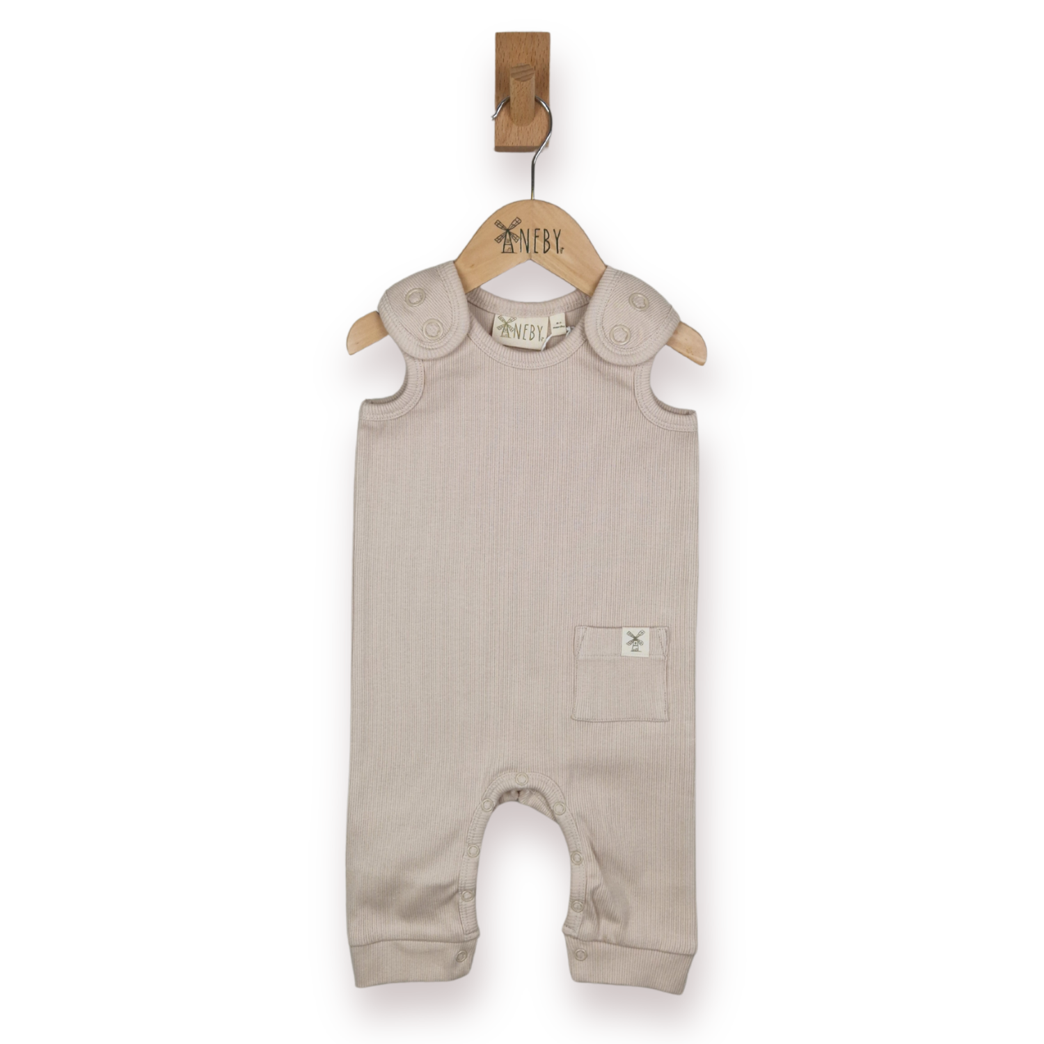 A baby sleeveless romper in a light taupe-beige colour, with shoulder straps and small pocket, hanging on a wooden hanger, against a plain white background.