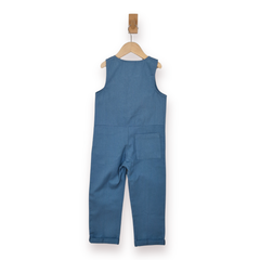 A sleeveless blue children's jumpsuit or overall-style romper hanging on a wooden hanger against a plain white background.