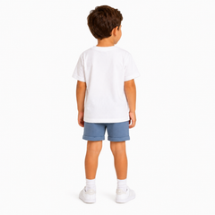 A child model shown from the back wearing a plain white short-sleeve t-shirt, blue shorts, white socks, and white trainers against a clean white background.