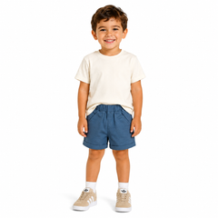 Blue chino shorts modelled by a young boy wearing a white t-shirt and Adidas trainers, against a white background. 