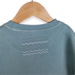 Blue sweater with wave pattern on a wooden hanger