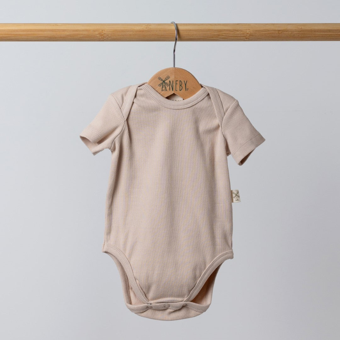 Short sleeve beige baby bodysuit with side seam windmill hem tag hanging on wooden rail