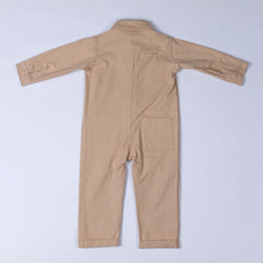 Rear view of the neutral beige cotton denim boilersuit with Aneby hem tag