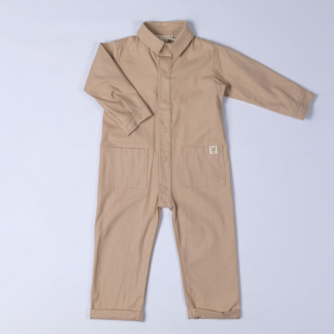 Product shot of the beige oat kids boilersuit with Aneby hem tag