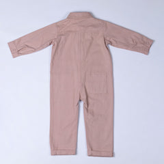 Rear view of the dusty pink cotton denim boilersuit with Aneby hem tag