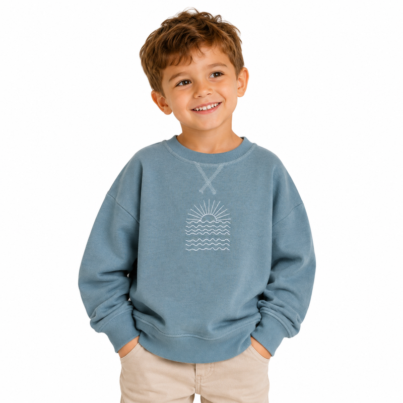 Child wearing a blue sweatshirt with a graphic design on a white background