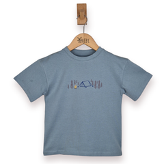 Blue t-shirt with a camping design on a wooden hanger against a white background