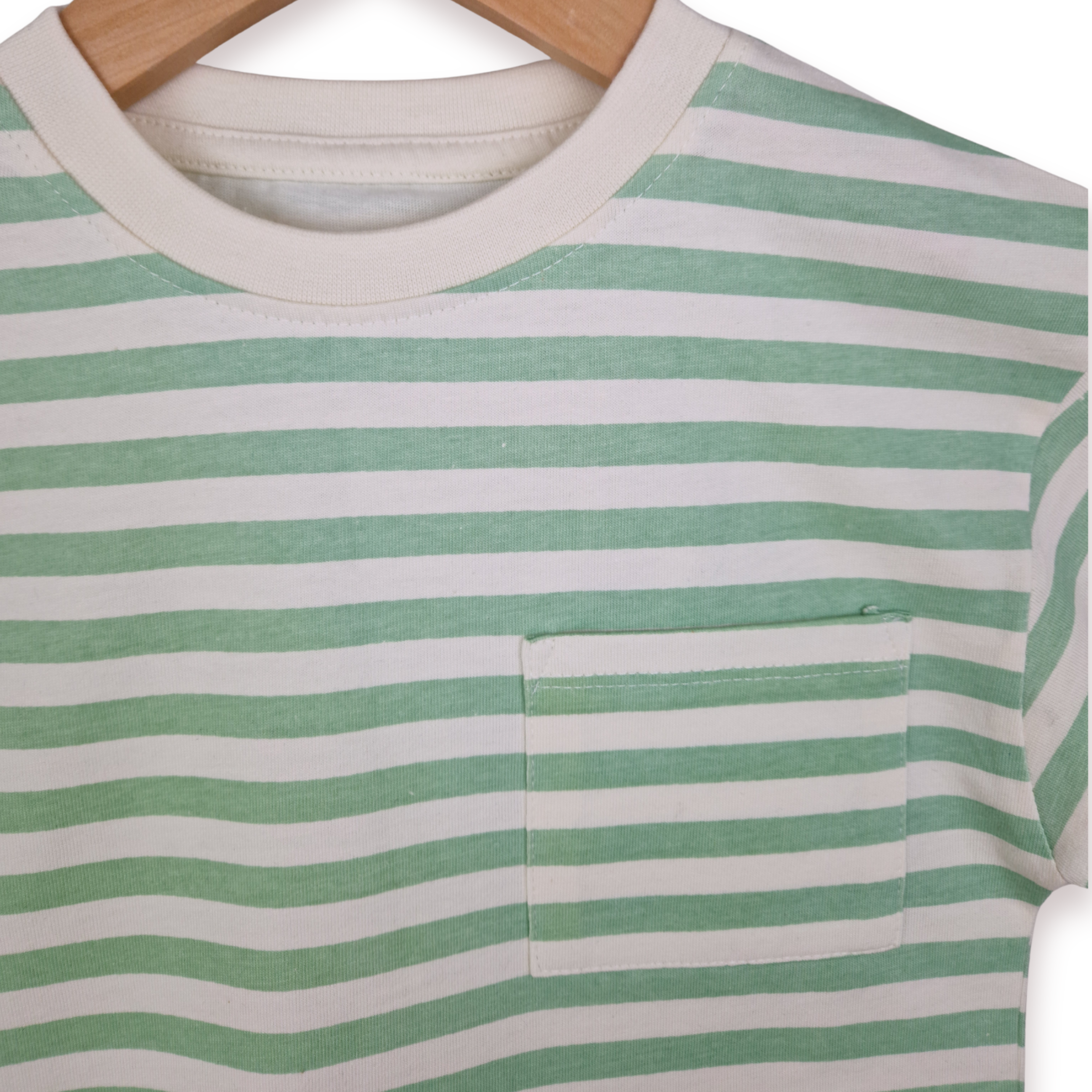 Close up photo of a boys green and ecru stripe t -shirt on a white background.