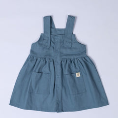 Slate blue pleated dress with shoulder straps, patch pocket and dyed to match poppers