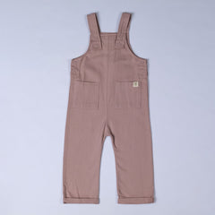 Dusty pink dungarees with shoulder straps, patch pockets, dyed to match poppers and rolled hem