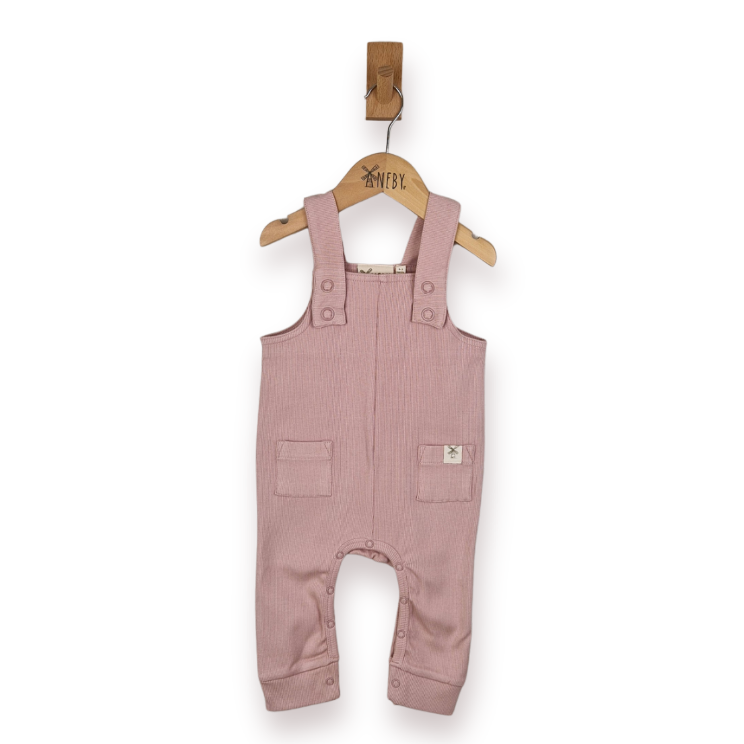 A dusty pink rib cotton baby romper hanging on a wooden hanger with a small wooden hook above it, against a plain white background.