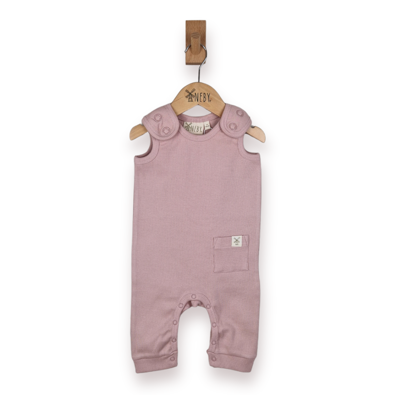 A dusty pink sleeveless baby romper with shoulder tabs and small patch pocket hanging from a wooden hanger on a white background.