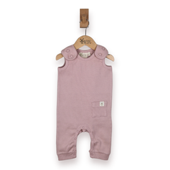 A dusty pink sleeveless baby romper with shoulder tabs and small patch pocket hanging from a wooden hanger on a white background.
