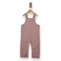 A dusty rose pink corduroy baby overall romper hanging on a wooden hanger against a clean white background.