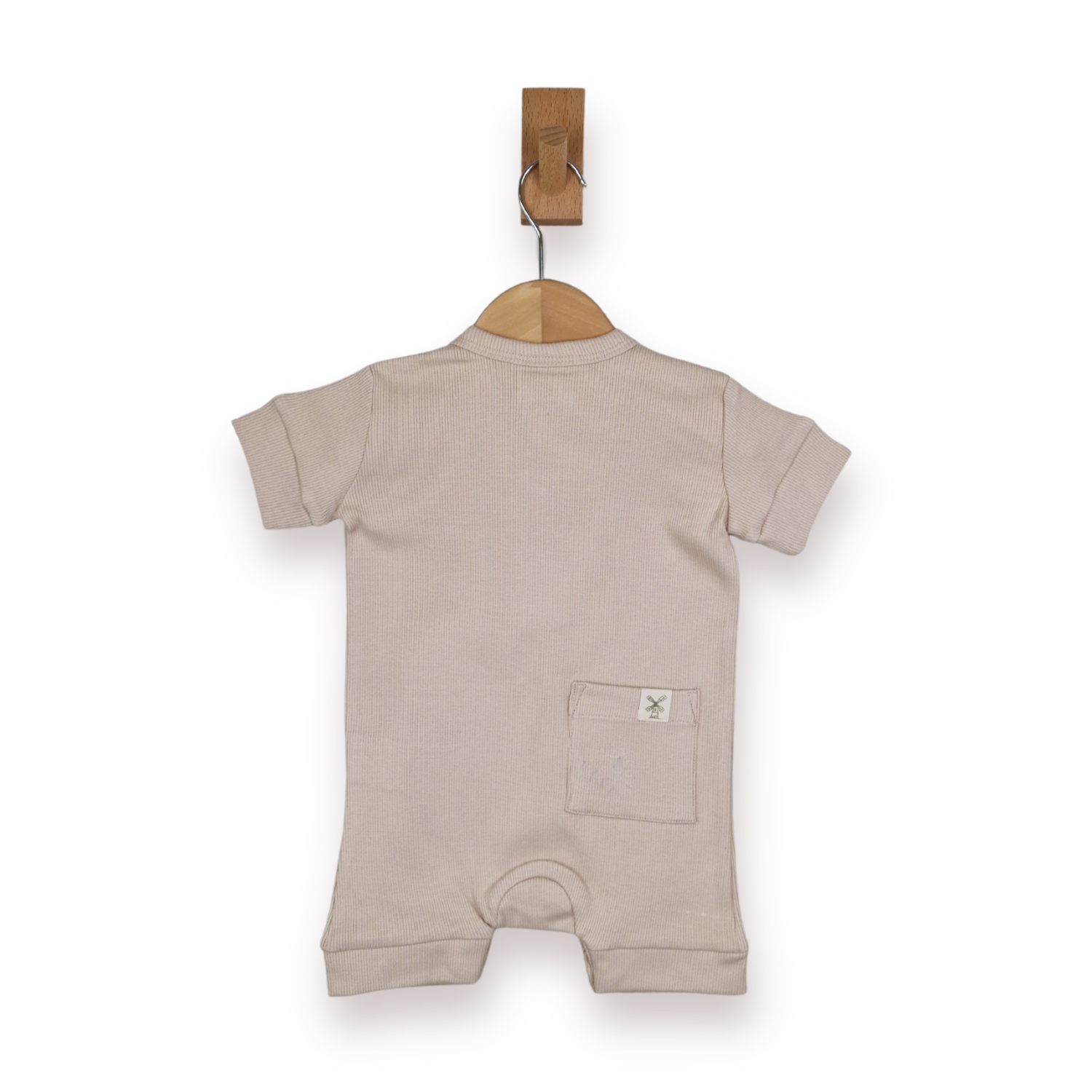 A light beige short-sleeve baby romper hanging on a wooden hanger from a brown wall hook, shown against a plain white background.