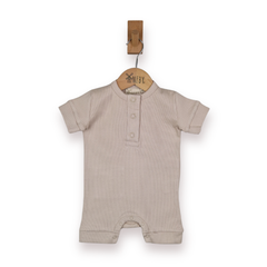 A baby short-sleeve romper in a light beige colour, hanging on a wooden hanger with a wooden peg against a plain white background.