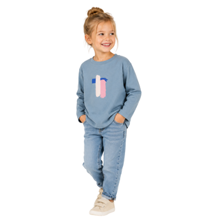 Girl wearing cool blue long sleeve t shirt and jeans. Standing against a white background
