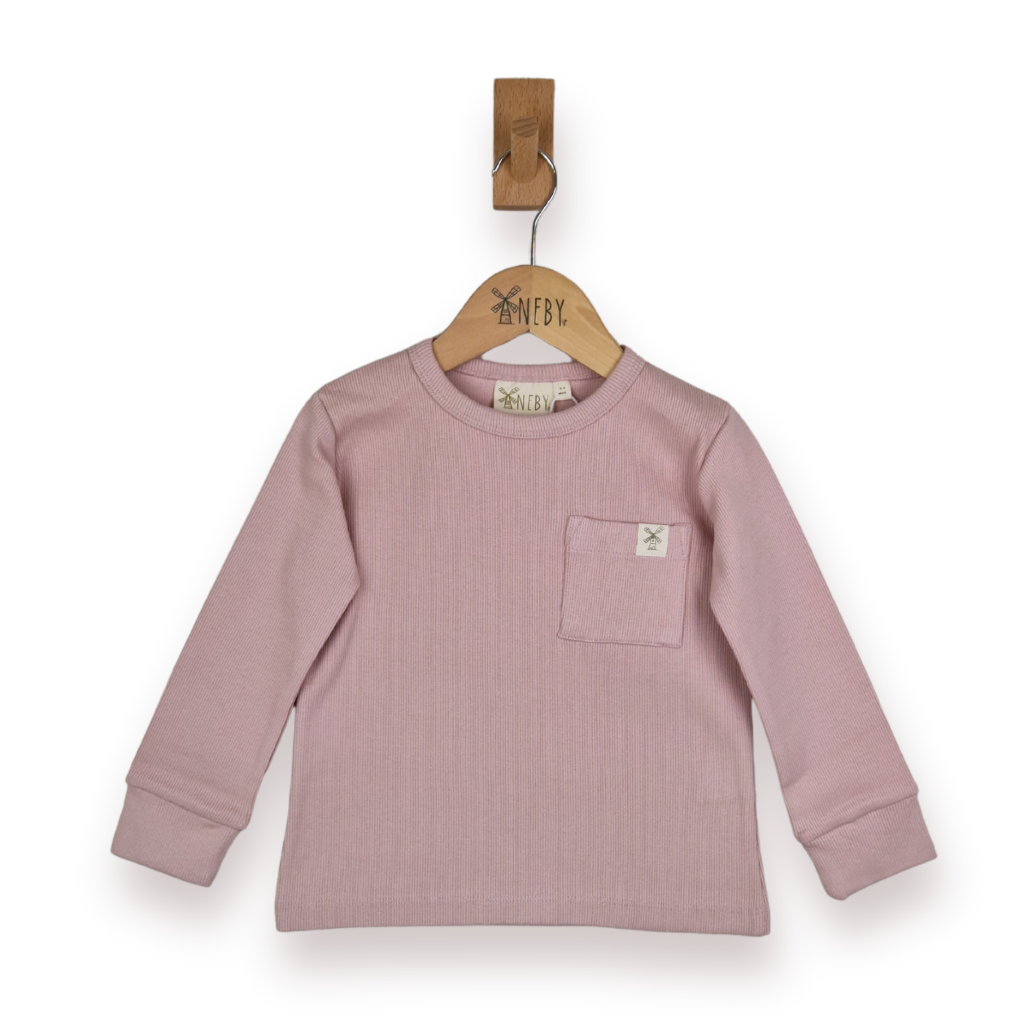 A dusty pink ribbed long-sleeve top for kids, featuring a chest pocket with a small logo patch, hanging on a wooden hanger with a wooden peg against a white background.