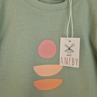Close up of design on kids' long sleeve green t-shirt. 
