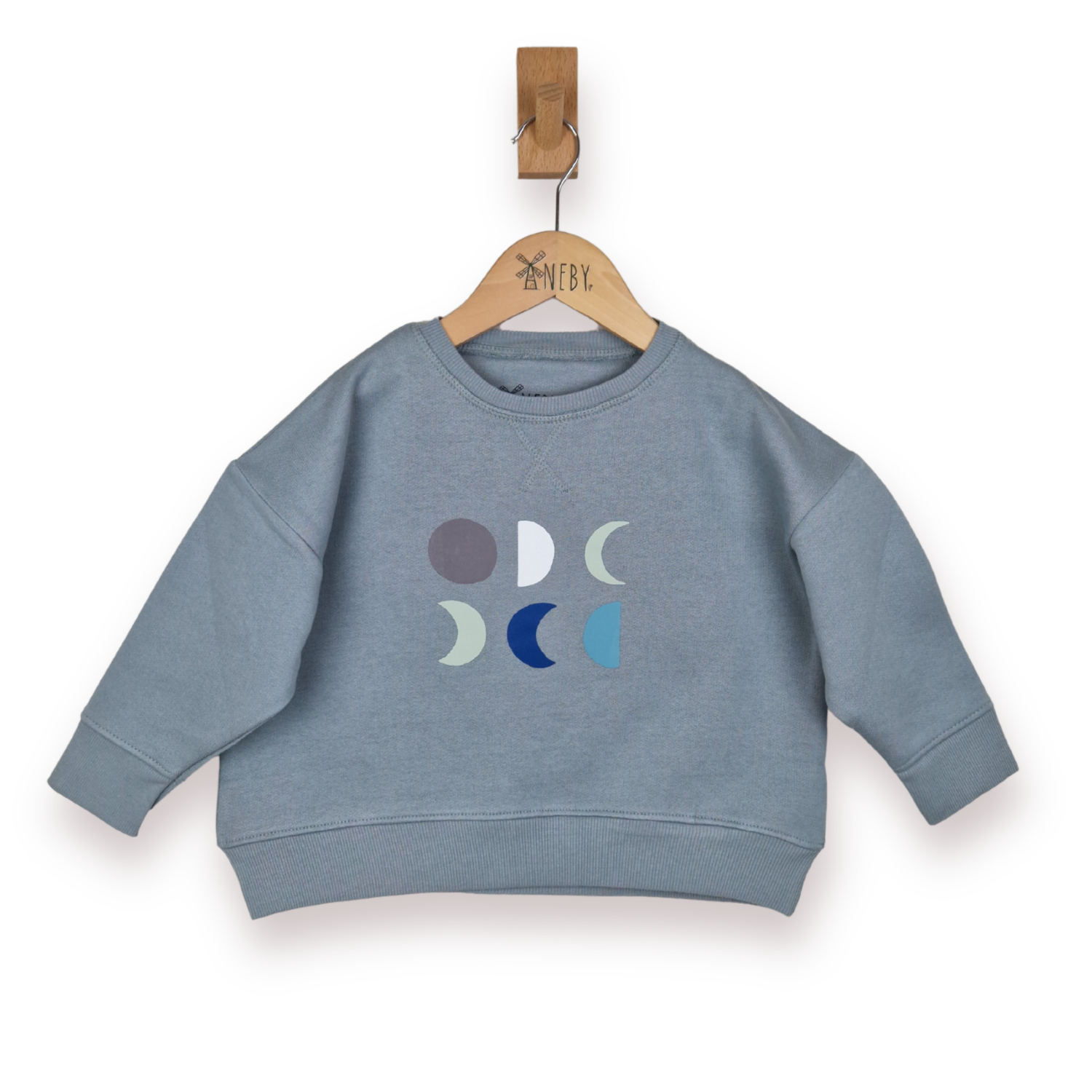 Blue grey sweatshirt with moon phase design on a hanger against a white background