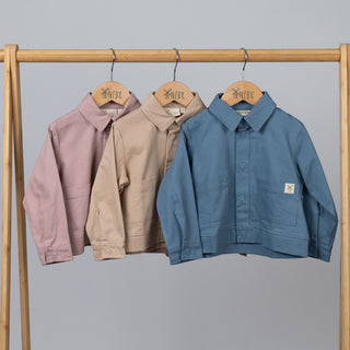 Three Aneby boxy shirts in pink, oat and slate blue; featuring a pointy collar and patch pocket