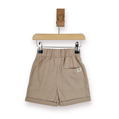 A pair of beige elastic-waist shorts with a single back patch pocket, hanging from a wooden hanger on a white background.