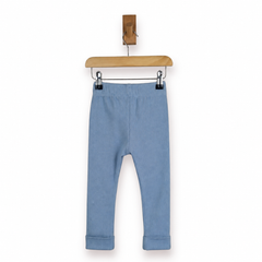 Dusty blue children's leggings with an elastic waistband and rolled cuffs, hanging from a wooden hanger against a plain white background.