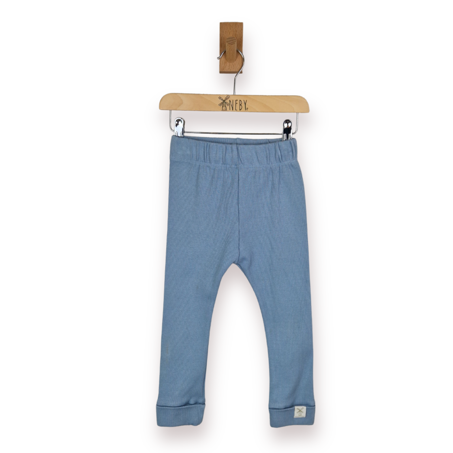 A pair of kids leggings in a blue, hanging from a wooden hanger, against a plain white background.