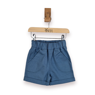 Blue high-waisted shorts with an elastic waistband and side pockets, hanging from a wooden hanger on a white background.