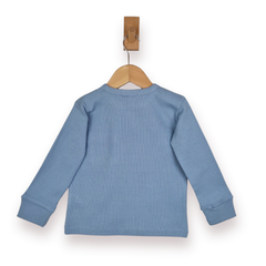 A light blue long-sleeve rib knit top shown from the back, hanging on a wooden hanger with a wooden peg against a plain white background.