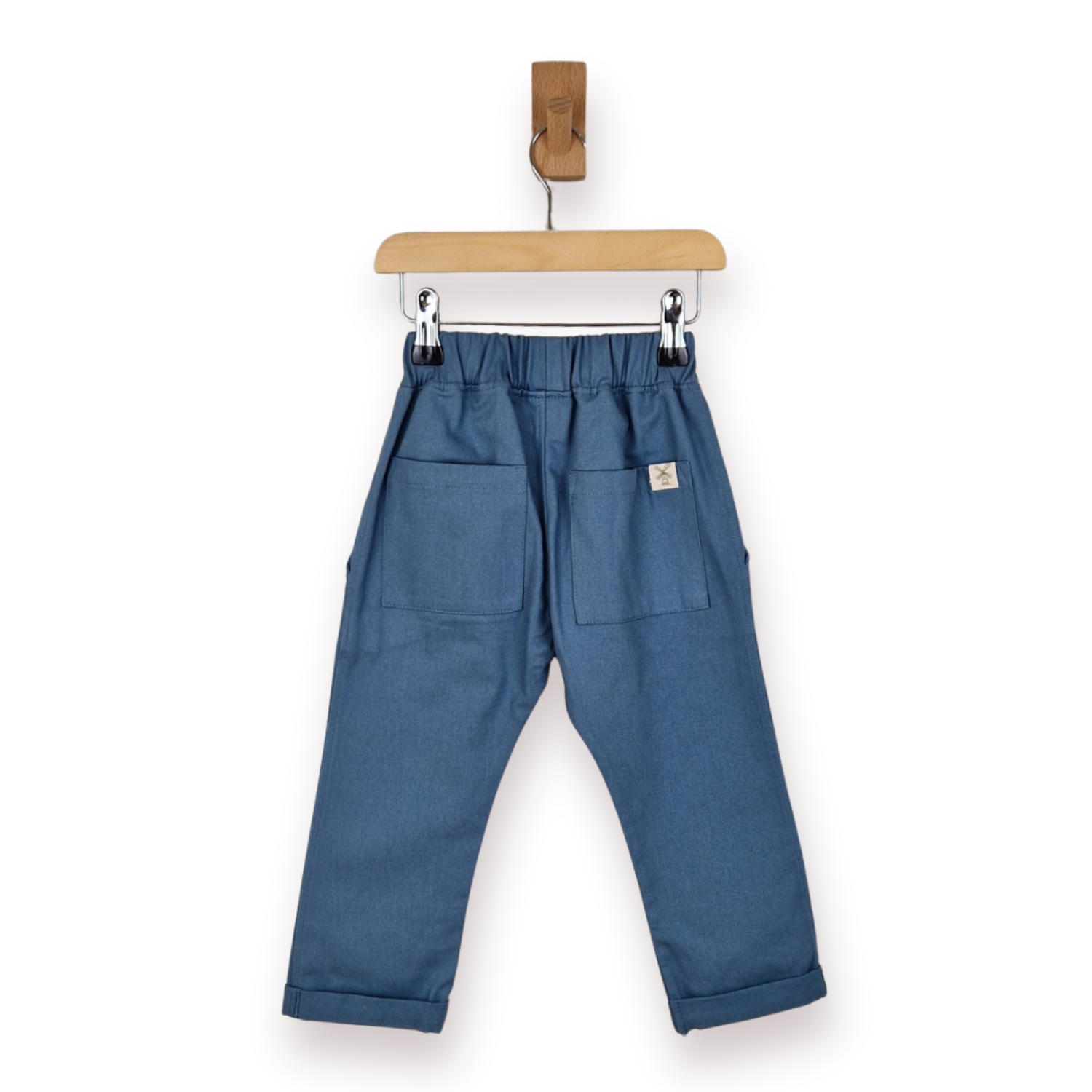 Blue chino trousers with an elastic waistband, two large patch pockets, and rolled cuffs, hanging from a wooden hanger on a white background.
