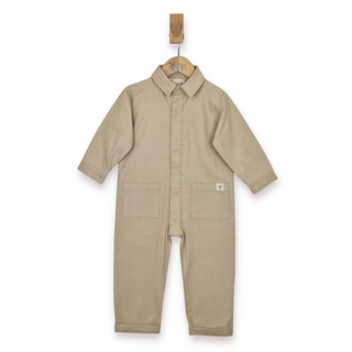 Ecru boilersuit, with collar, poppers and front patch pockets. Image taken against a white background, hanging from a wooden Aneby hanger. 