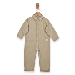 Ecru boilersuit, with collar, poppers and front patch pockets. Image taken against a white background, hanging from a wooden Aneby hanger. 