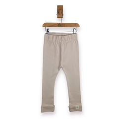 A pair of light beige toddler leggings hanging from a wooden hanger on a white background.