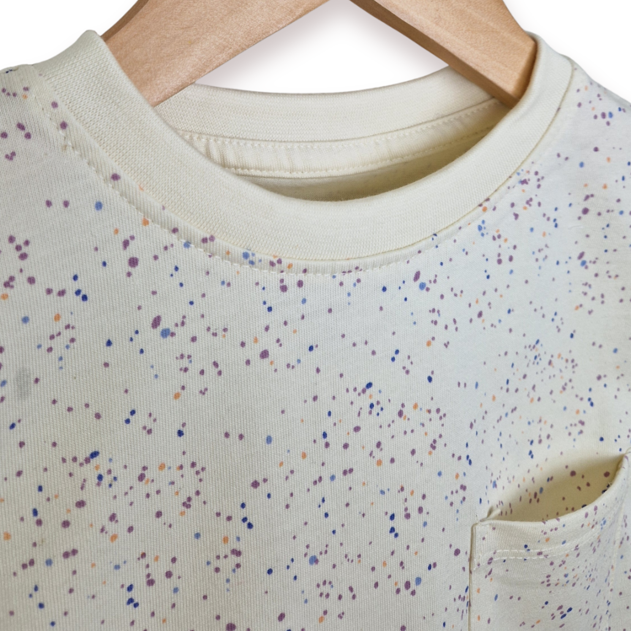 White shirt with colorful speckles on a hanger