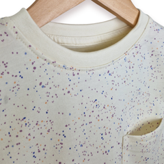 White shirt with colorful speckles on a hanger