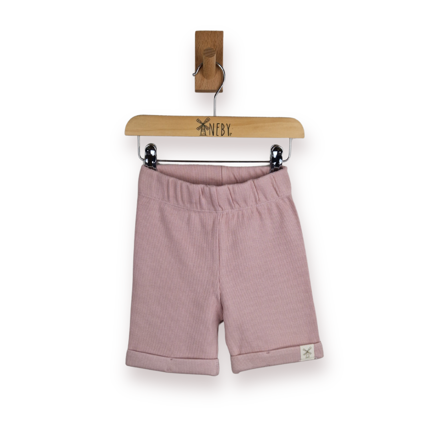 A pair of dusty pink ribbed knit shorts for toddlers, hanging from a wooden hanger against a clean white background.