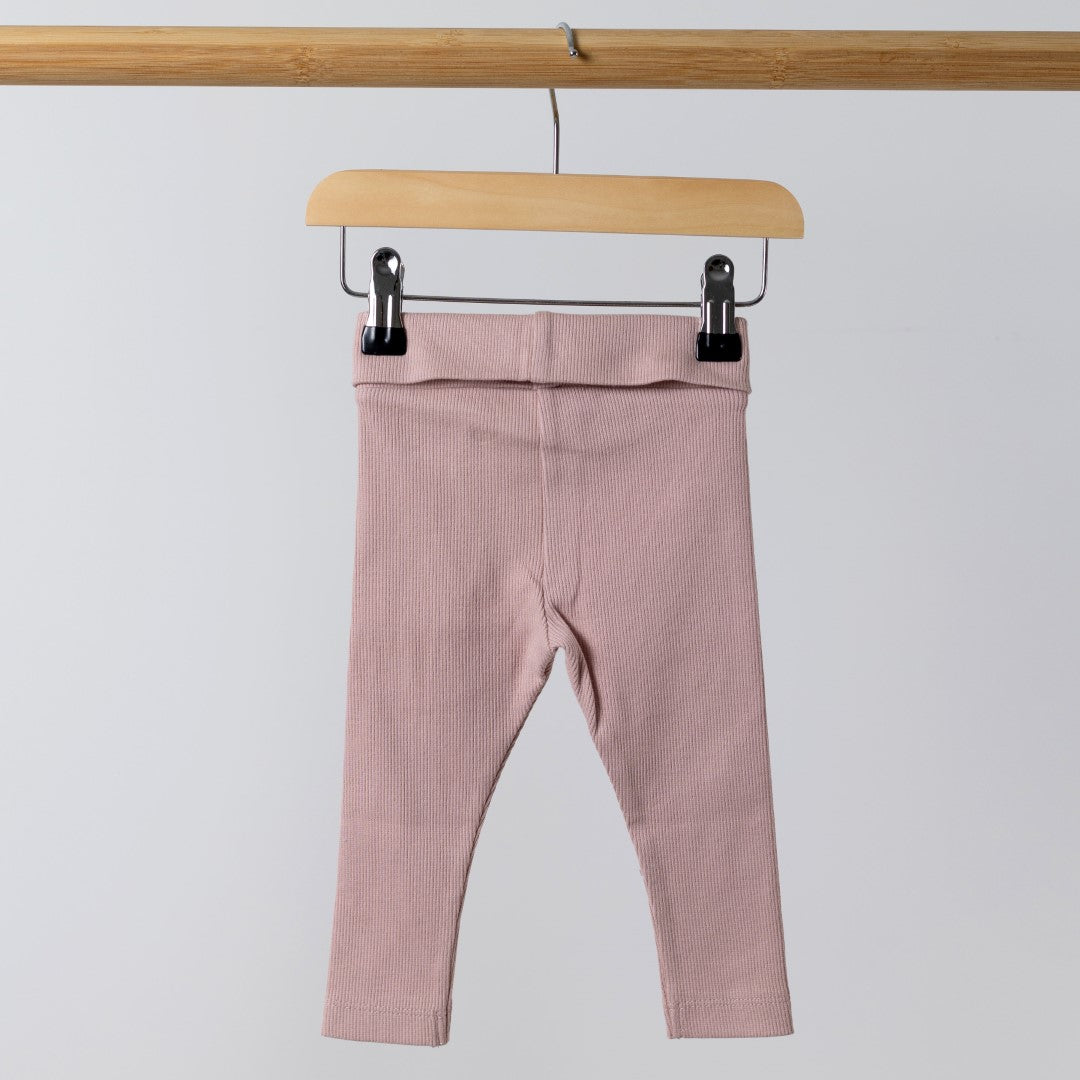 Rear view of baby pink rib leggings on wooden hanger