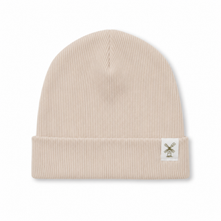 A ribbed knit beanie hat in a light beige or cream colour, featuring a small white square patch on the folded cuff with a windmill graphic.