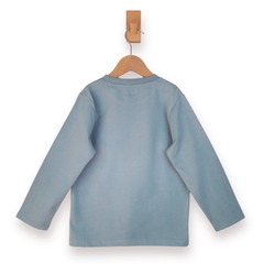 Blue long sleeve t shirt on a wooden hanger against a white background