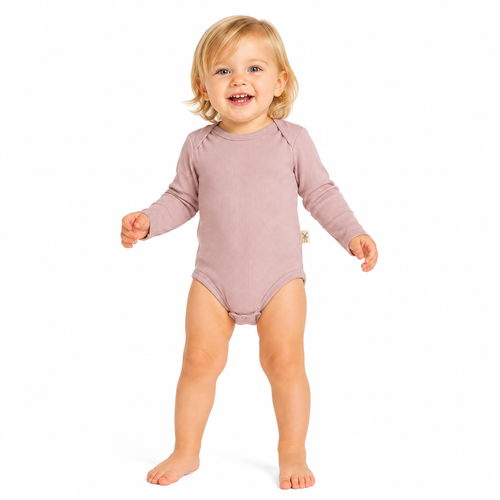 A smiling toddler standing barefoot on a white background, wearing a long-sleeve bodysuit in a muted dusty pink colour.